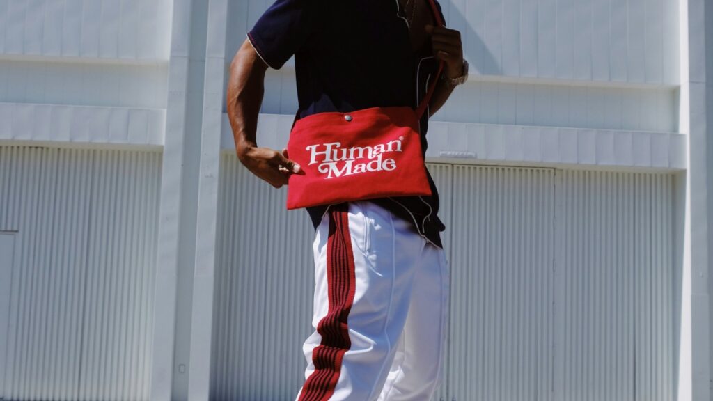 Persona con look urbano casual y bolso rojo, combinando prendas deportivas y estilo de ciudad.