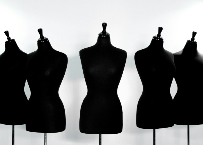 Cinco maniquíes de costura en negro, imagen relacionada con diseño de moda y confección.