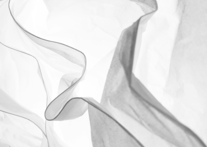 Tela blanca translúcida en movimiento, imagen asociada a tejidos ligeros y moda sostenible.